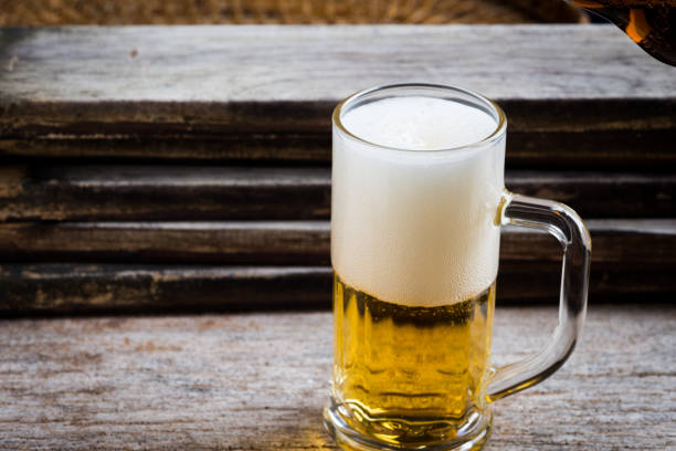 istock mug of beer on wood background 1045696174