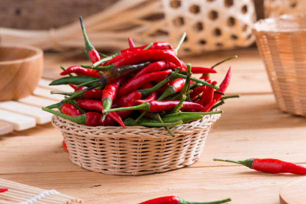 Red hot chili peppers in basket on wooden table