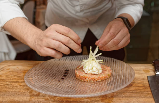 istock Chef is decorating salmon tartar with apple 1045696448