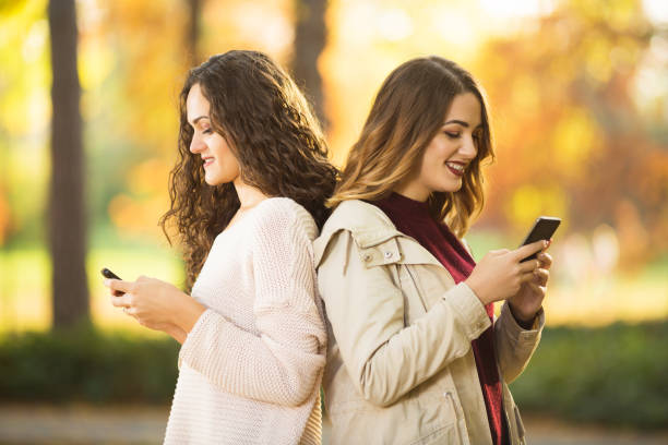 istock Two young women using their phones 1045700110