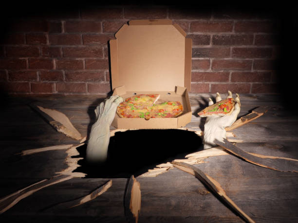 istock Zombie hand through hole cracked in rustic wood.Halloween theme 1045707988