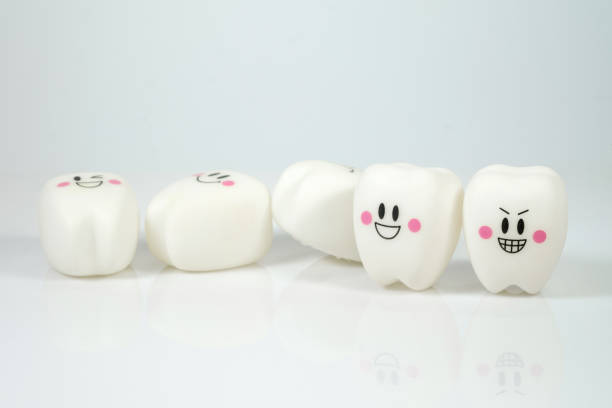 istock Smiley Plastic teeth toy on a gray background, poor dental care concept, falling teeth 1045727938
