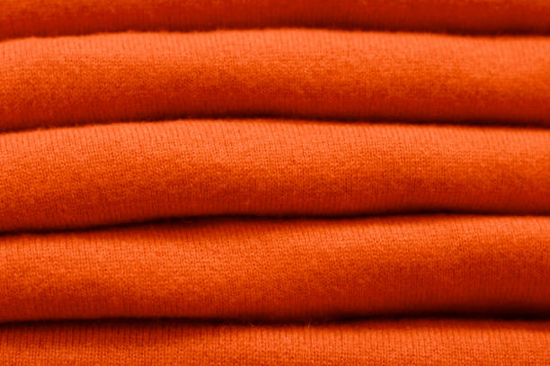 istock Stack of trend Russet Orange woolen sweaters close-up, texture, background 1045728042
