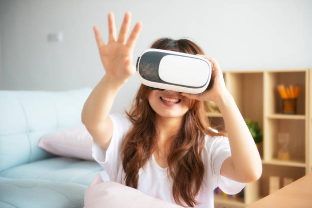 istock Young Cheerful Woman Wearing Virtual Reality Headset Playing 360 Vr Video 1045732436