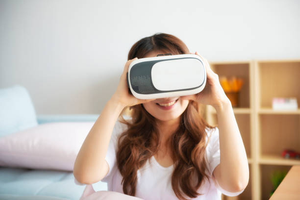 istock Young Cheerful Woman Wearing Virtual Reality Headset Playing 360 Vr Video 1045732474
