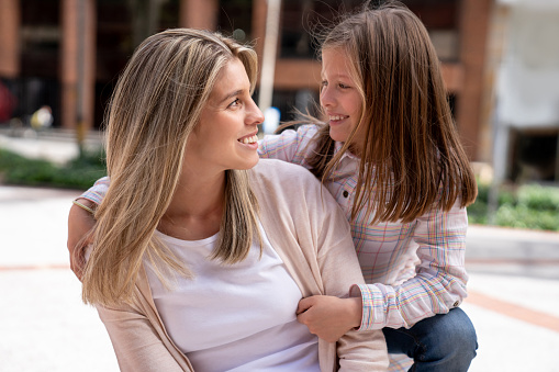 Portrait of a happy mother and daughter hugging and smiling - lifestyle concepts