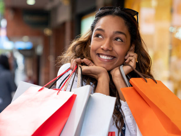 ショッピング袋を保持している非常に満足して女性を興奮 - spending money adult african ethnicity bag ストックフォトと画像