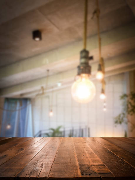 Empty perspective wood plank table top with blur coffee shop or restaurant interior background