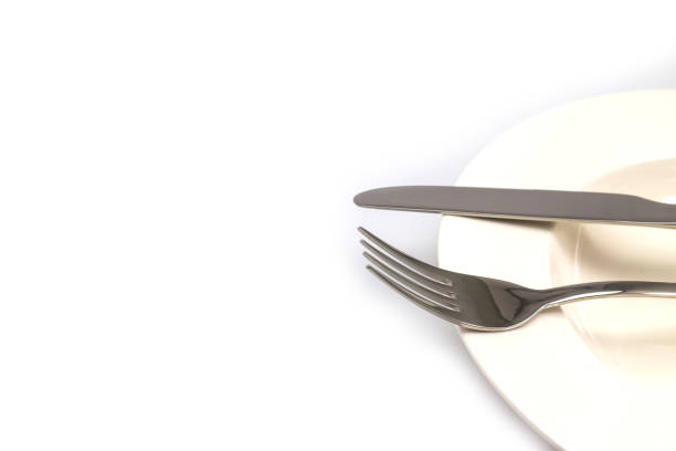 istock Stainless steel fork and knife on a white plate isolated 1045791926