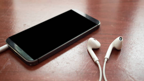 istock smartphone and earphone close up on wood table 1045808930