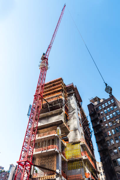 Skyscrape construction site with crane against blue sky Skyscraper construction site with crane against blue sky background. New York skyscraper office building built structure new york city stock pictures, royalty-free photos & images