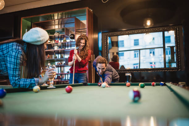 istock Group of friends spending time together, drinking beer,  playing snooker 1045827078