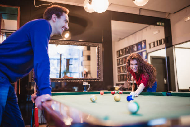 istock Group of friends spending time together, drinking beer,  playing snooker 1045827114