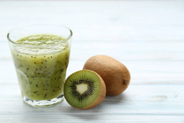 istock Fresh kiwi smoothie in glass on wooden table 1045832696
