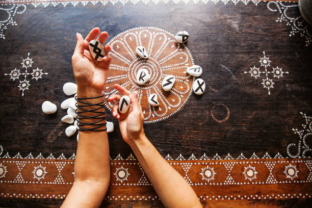 Runes hands holding runes stones on an ornate table runes stock pictures, royalty-free photos & images