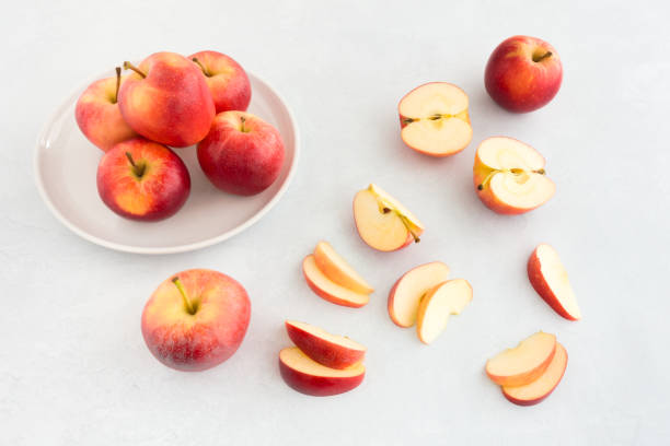 Whole and Cut Apples on White Textured Background