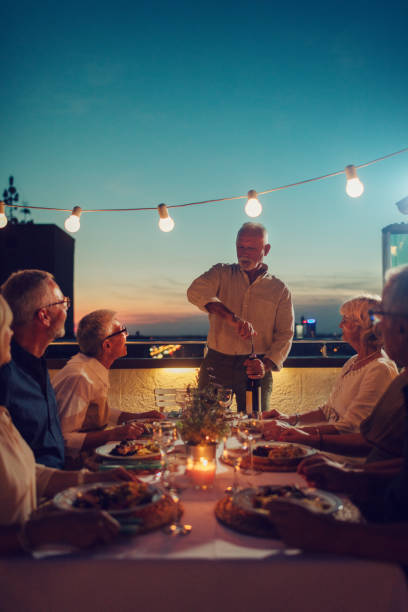 seniors having dinner on rooftop - dining senior adult friendship mature adult imagens e fotografias de stock