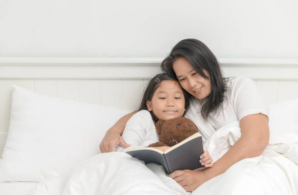 istock Mother read book with daughter 1045841982