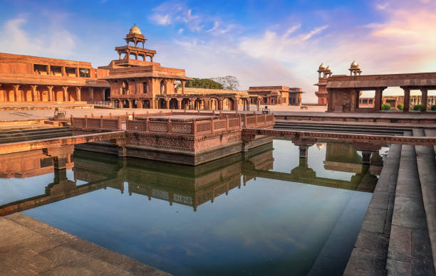 Fatehpur Sikri Anup Talao red sandstone architectural structure at sunset with moody sky.