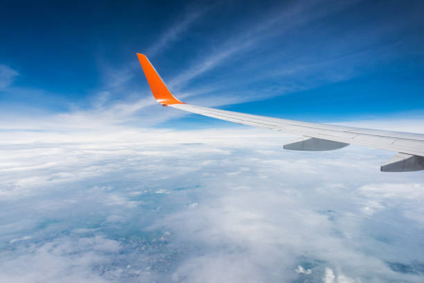 istock Aerial view of clouds and blue sky through airplane window 1045845138