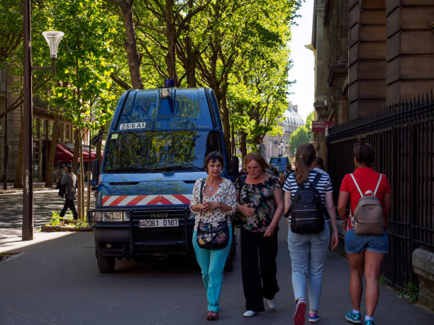 people walk near police minivans, paris, france - jihad imagens e fotografias de stock
