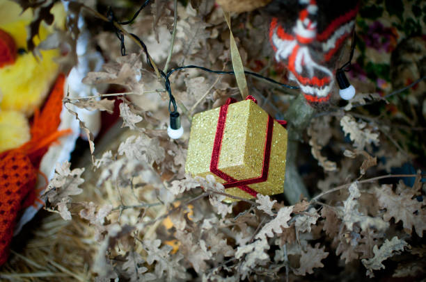 istock Decorative yellow little gift as ornament on oak Christmas tree 1045853242