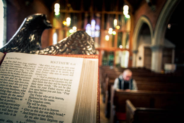 istock Young Man Praying inside Church with Bible 1045873240
