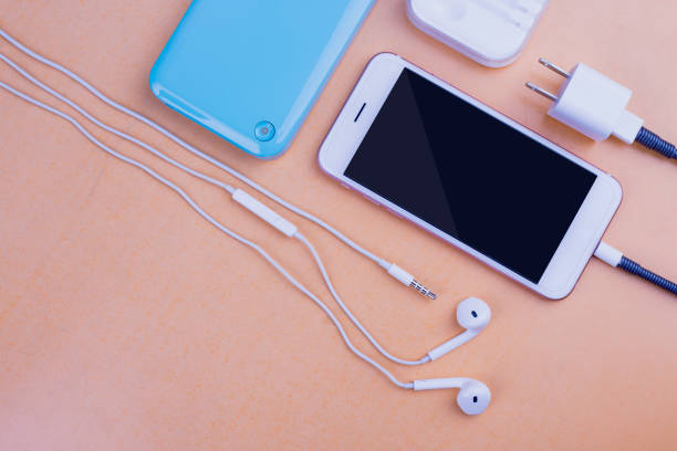 istock Smart phones and charging. On the table Orange background 1045873256