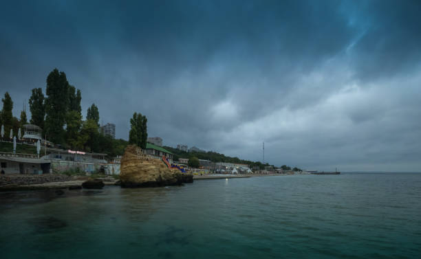 Otrada Beach in Odessa, Ukraine Odessa, Ukraine - 09.09.2018. Otrada beach in Odessa, Ukraine, in a gloomy summer morning. Dark clouds asperatus over the sea until dawn. odessa beach stock pictures, royalty-free photos & images