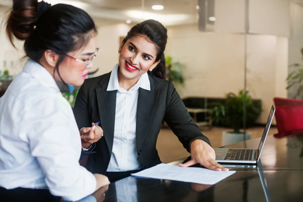 woman thinking before signing an agreement - endorsing business application form filling imagens e fotografias de stock