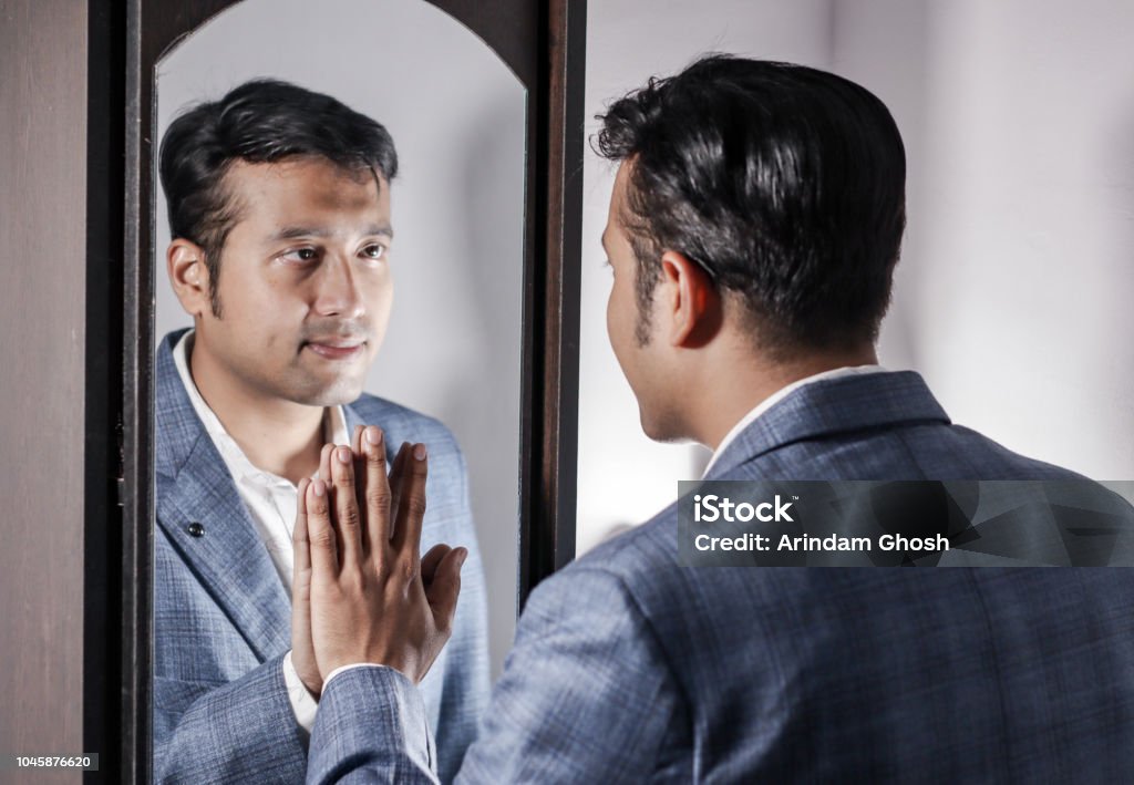 asian man in suit looking after his appearance in front of a mirror beauty styling lifestyle. Mirror - Object Stock Photo