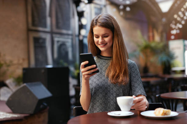 istock Woman With Mobile Phone In Cafe 1045877396