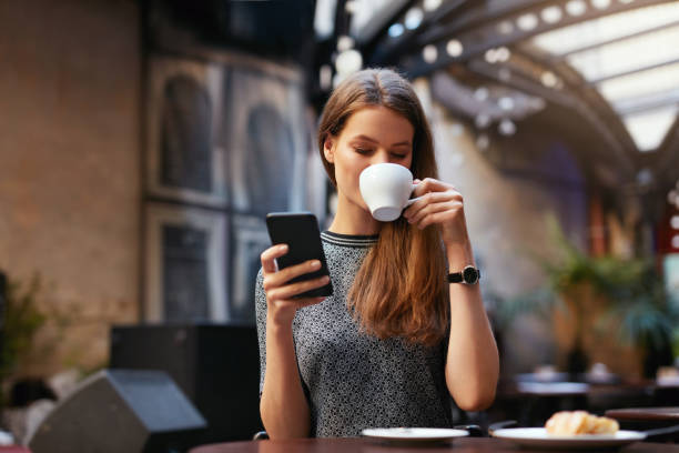 istock Woman With Mobile Phone In Cafe 1045877410