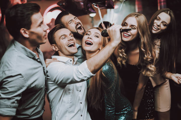 Sing. Men. Dance Club. White Shirt. Young People. Holidays Concept. Dancing People. Great Mood. Young People. Dance Club. Sing. Microphone. Trendy Modern Nightclub. Party Maker. Birthday. Karaoke Club. Celebration. Men. White Shirt. karaoke stock pictures, royalty-free photos & images