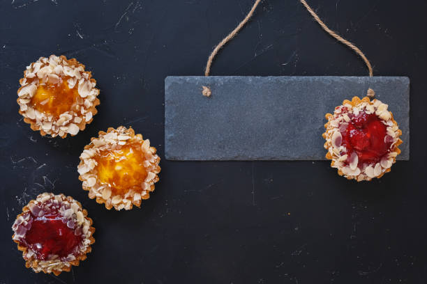 istock Small tarts with different fillings, topped with some sliced almonds 1045880432