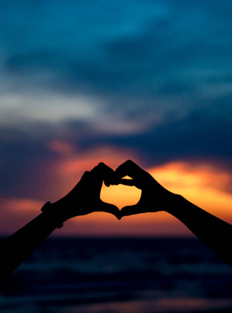 istock Hand making keep love and heart shape with sunset silhouette ,copy space,warm retro tone. 1045887744