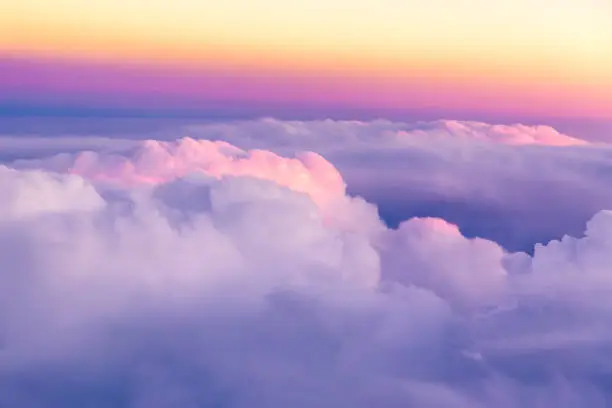 Photo of Beautiful sunset sky above clouds with nice dramatic light. View from airplane window