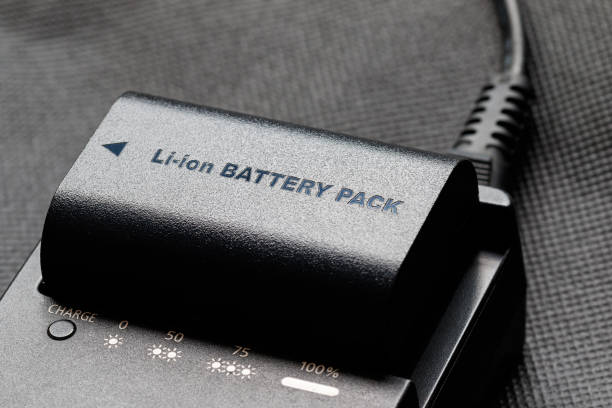 Rechargeable lithium-ion battery with charger Rechargeable lithium-ion battery with charger lithium ion battery stock pictures, royalty-free photos & images