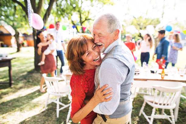 um casal sênior dançando em uma festa no jardim lá fora no quintal. - clothing love smiling parent - fotografias e filmes do acervo