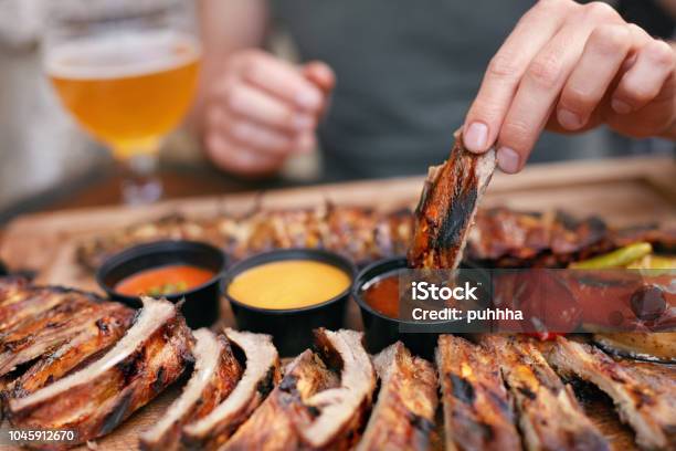 Barbecue Ribs With Sauсes Closeup Stock Photo - Download Image Now - Barbecue - Meal, Barbecue Grill, Eating