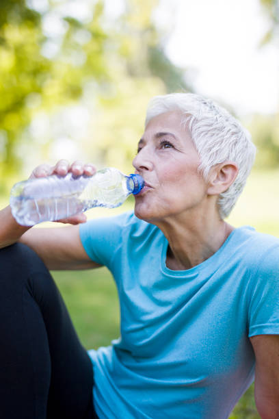 istock Senior woman rests and drinks water after workout 1045912728