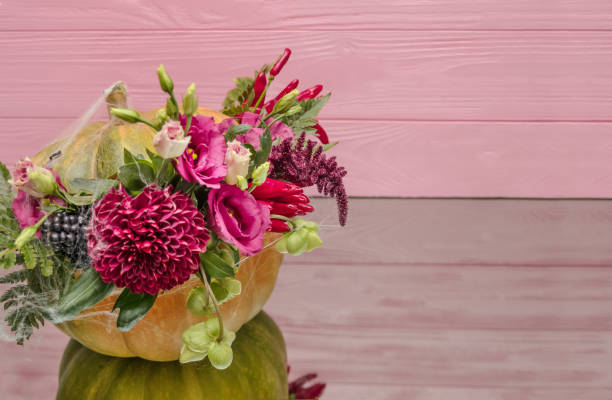 istock Halloween pumpkin with flowers and leaves on mirror table. 1045922476