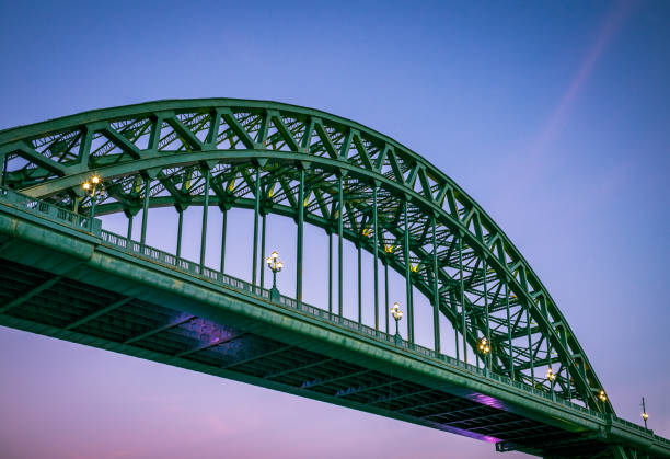 Tyne Bridge in Newcastle, illuminated at dusk The famous traditional arch structure of the Tyne Bridge in central Newcastle, England. tyne bridge stock pictures, royalty-free photos & images