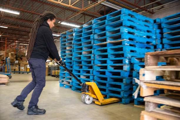 istock A warehouse worker moving a stack of pallets with a pallet jack 1045938894