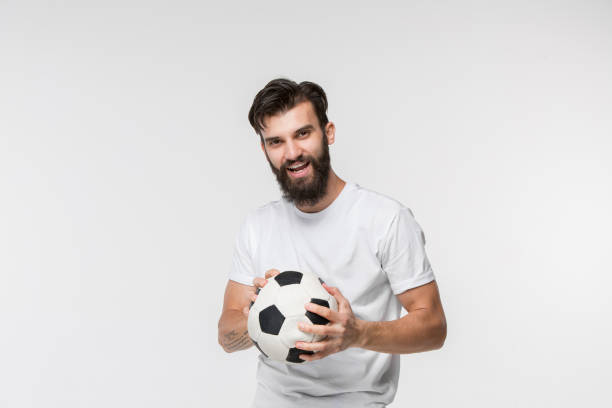 istock Young soccer player with ball in front of white background 1045942588