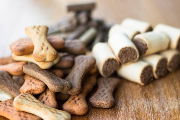 Dog tasty colored biscuits on wooden background, snacks for dogs