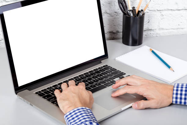 istock Closeup view of hands working at a laptop with empty white screen. Mockup with copy space 1045957246