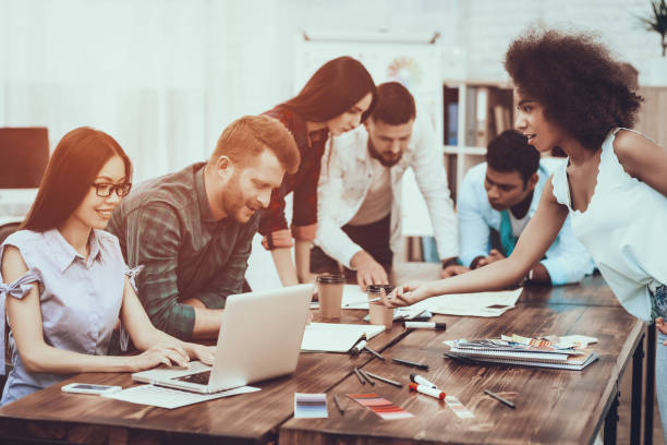 istock Group of Young People. Laptops. Pens. Notepads. 1045960340