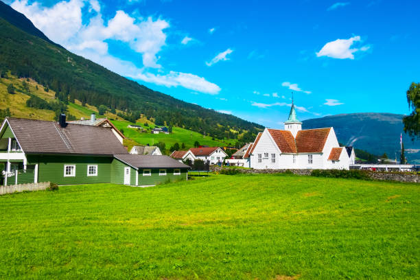 Norway, Olden - August 1, 2018: Norwegian village landscape with meadows, mountains, church and colorful houses. Olden, Norway