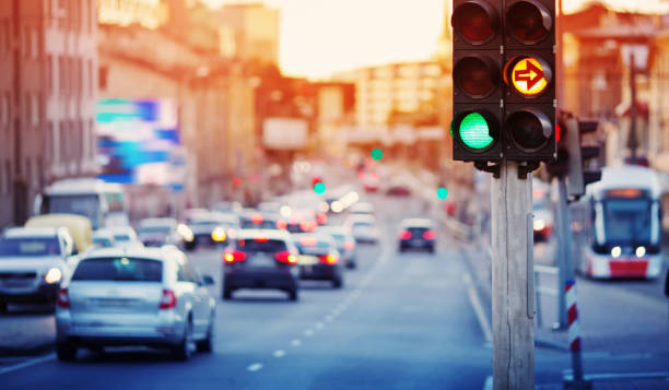 автомобили движутся по дороге в городе поздним вечером - road signal стоковые фото и изображения